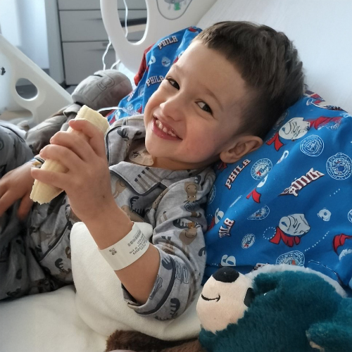 Julian smiles bravely from his bed after surgery at St. Christopher's Hospital for Children