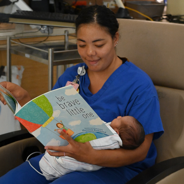A nurse reading to an infant in the Reading Hospital Level III NICU