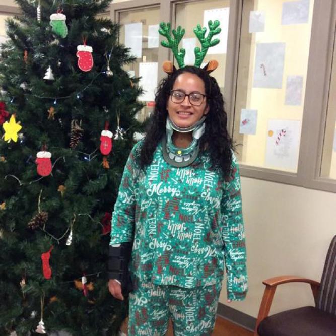 Rosemerry Aviles Leandry, rehab patient, standing with Christmas tree
