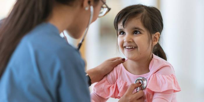 Doctor listening to girl's heart