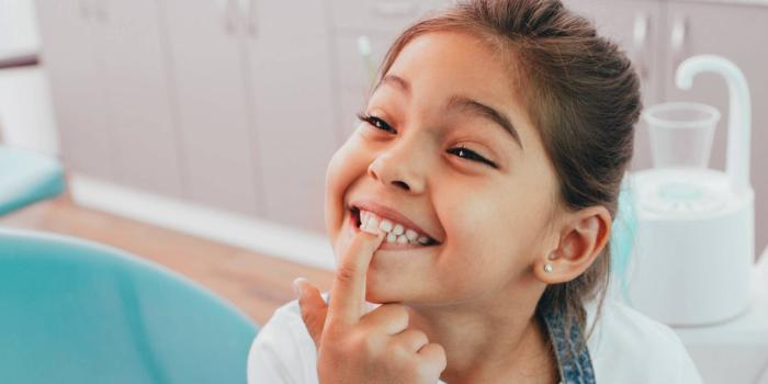 Girl pointing to her teeth