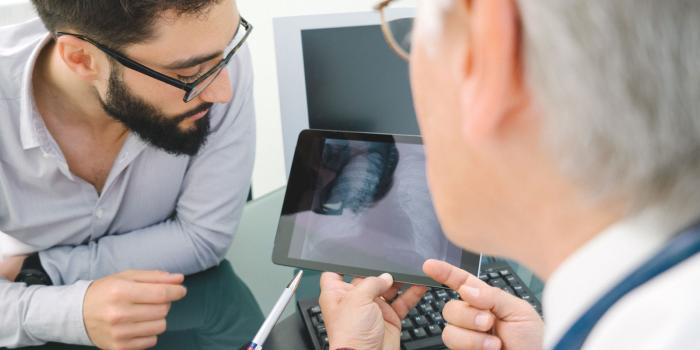 Two doctors looking at chest scan.