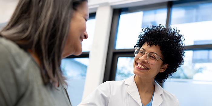 African-American doctor in lab coat smiling with patient