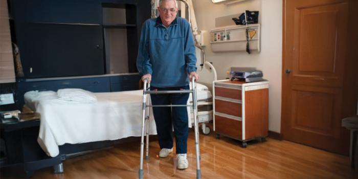 A person demonstrates how to use a walker by moving the walker first, then stepping with the operated leg, followed by the non operated leg.