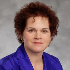 Caucasian female in purple blouse.