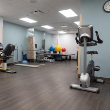 Therapy room with exercise machines, balance balls, and parallel bars